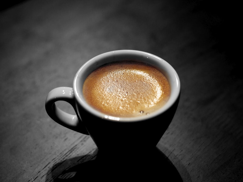 Espresso being pulled from professional machine with crema forming