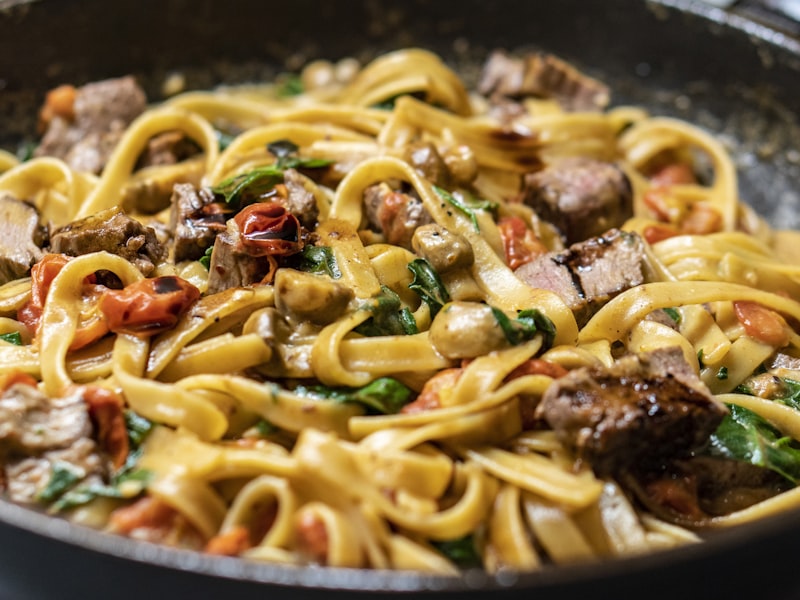 Fresh tagliatelle pasta nests on a floured surface