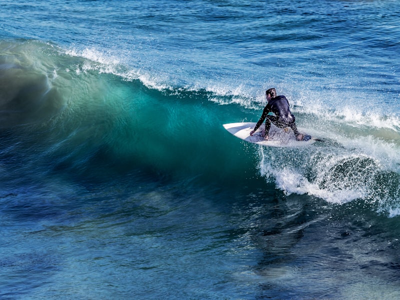 Surfer riding a wave with spray behind