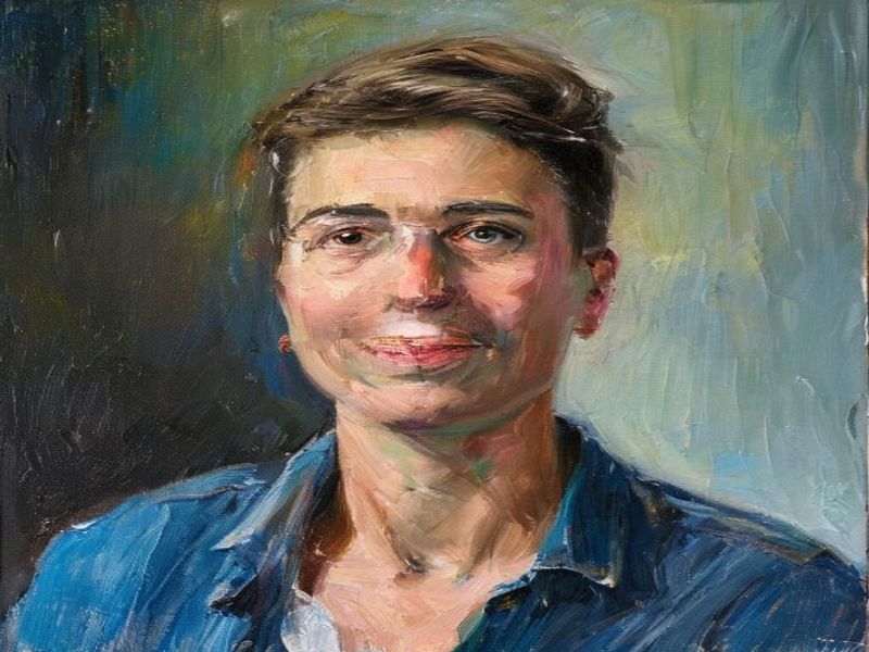 Artist painting a portrait on canvas at an easel